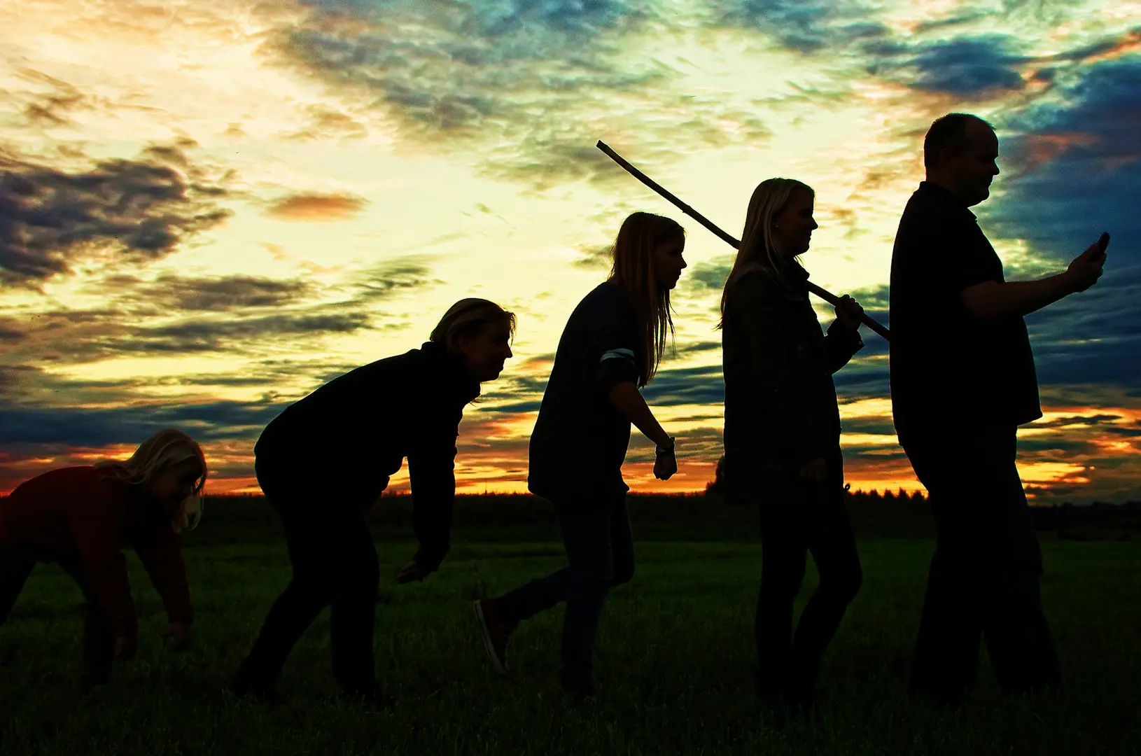 silhouette photo of group people standing on grass